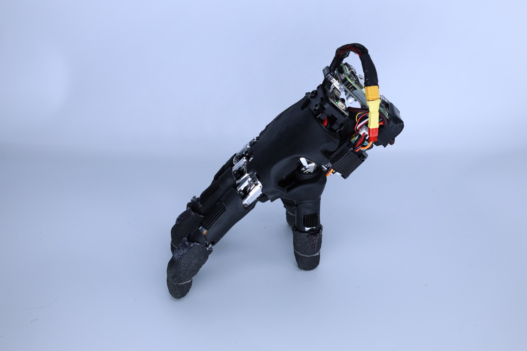 A robotic hand standing on its fingertips, with its battery and onboard computer above the palm